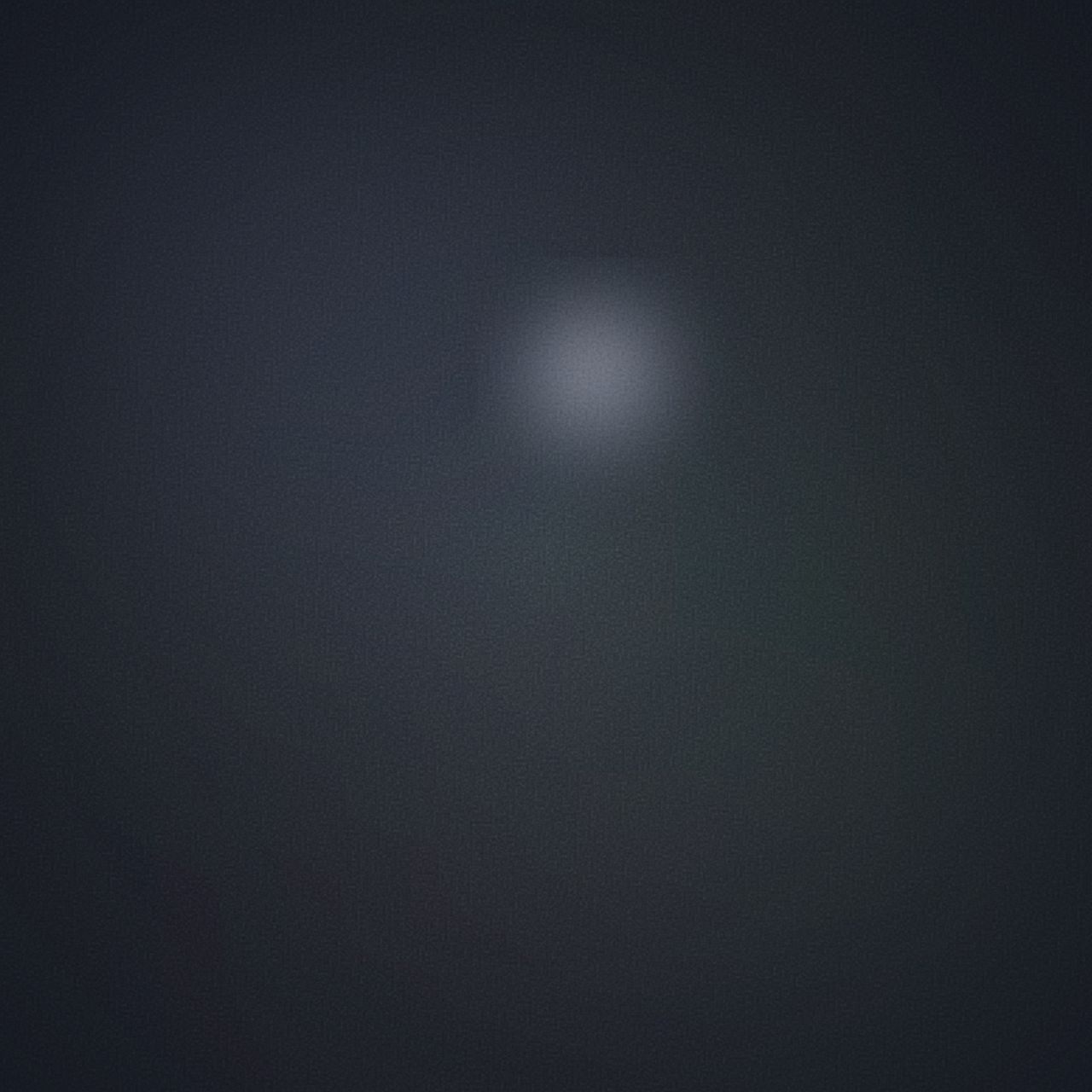 Dark blue-grey field with slate, forest, and plum blobs. A pale circle glows in the upper right like a moon through winter fog.